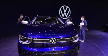 Visitors look at the latest electric car from Volkswagen during the Shanghai Auto Show in Shanghai, China, April 20, 2021. (AP Photo)