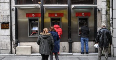 Customers wait in line to use the ATMs of a Turkish bank near the Eminönü neighborhood, in Istanbul, Turkey, March 22, 2021. (AFP Photo)