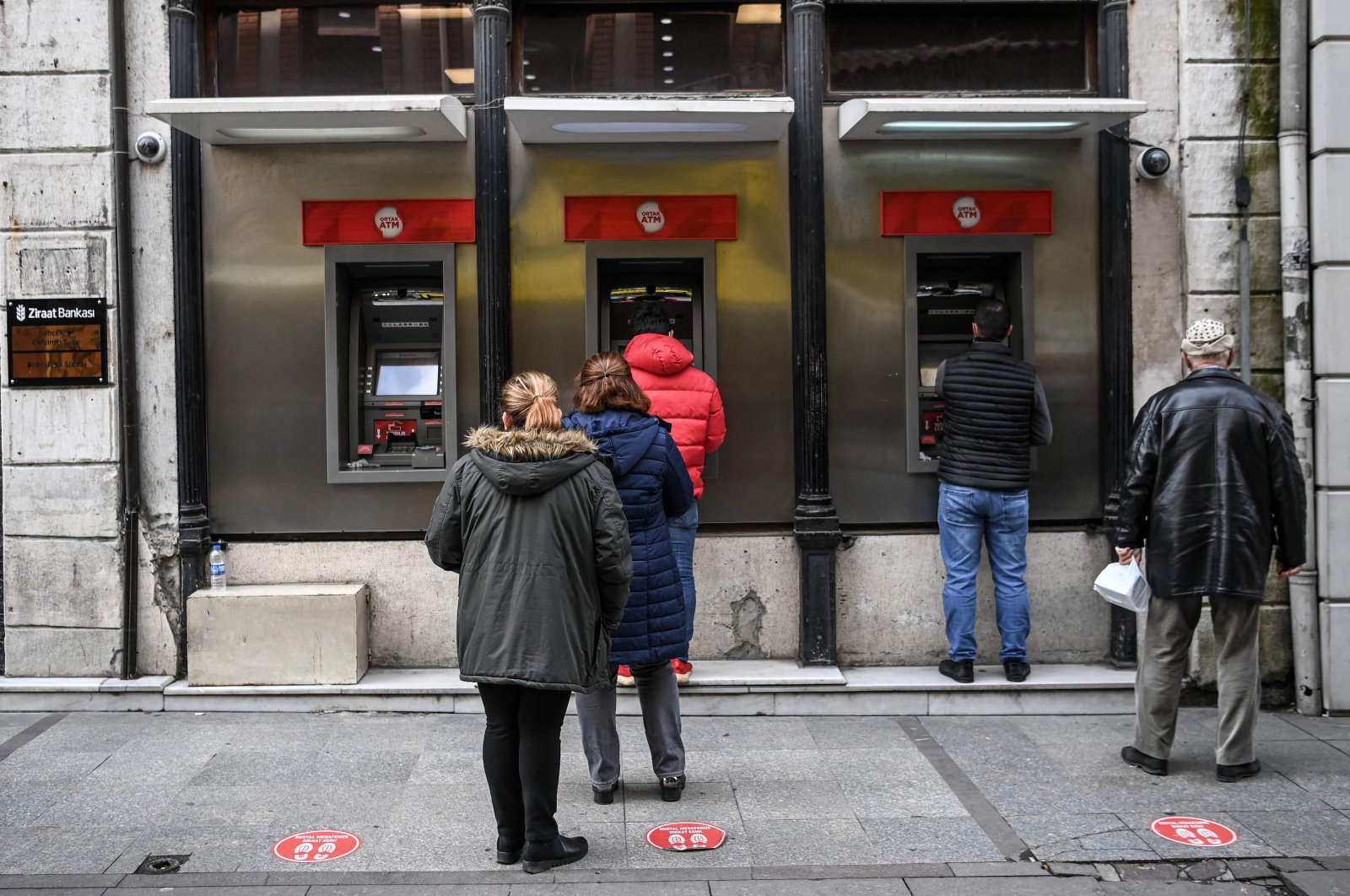 Customers wait in line to use the ATMs of a Turkish bank near the Eminönü neighborhood, in Istanbul, Turkey, March 22, 2021. (AFP Photo)
