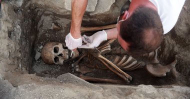 An archeologist works on a skeleton found at the Kadıkalesi archaeological site, Aydın, western Turkey, May 6, 2021. (AA Photo)