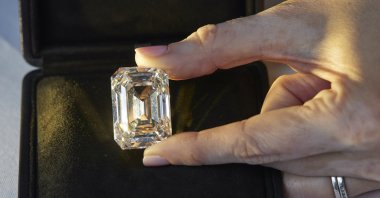 A Christie's staff member holds a D color, internally flawless rectangular step-cut diamond of 100.94 carats during a preview at Christie's before its auction sale in Geneva, Switzerland, May 7, 2021.  (Reuters Photo)