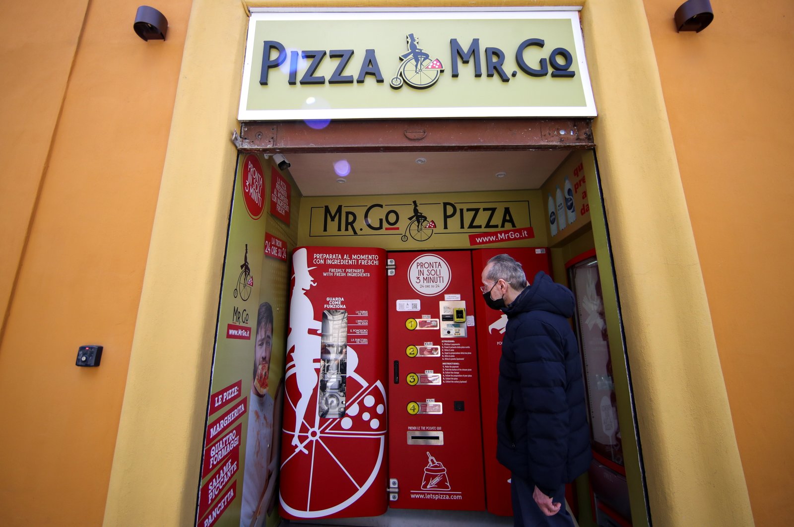 Claudio Zampiga waits for his order at the first automatic pizza vending machine, which is capable of kneading, seasoning and cooking the pizza in three minutes, in Rome, Italy, May 6, 2021. (Reuters Photo)