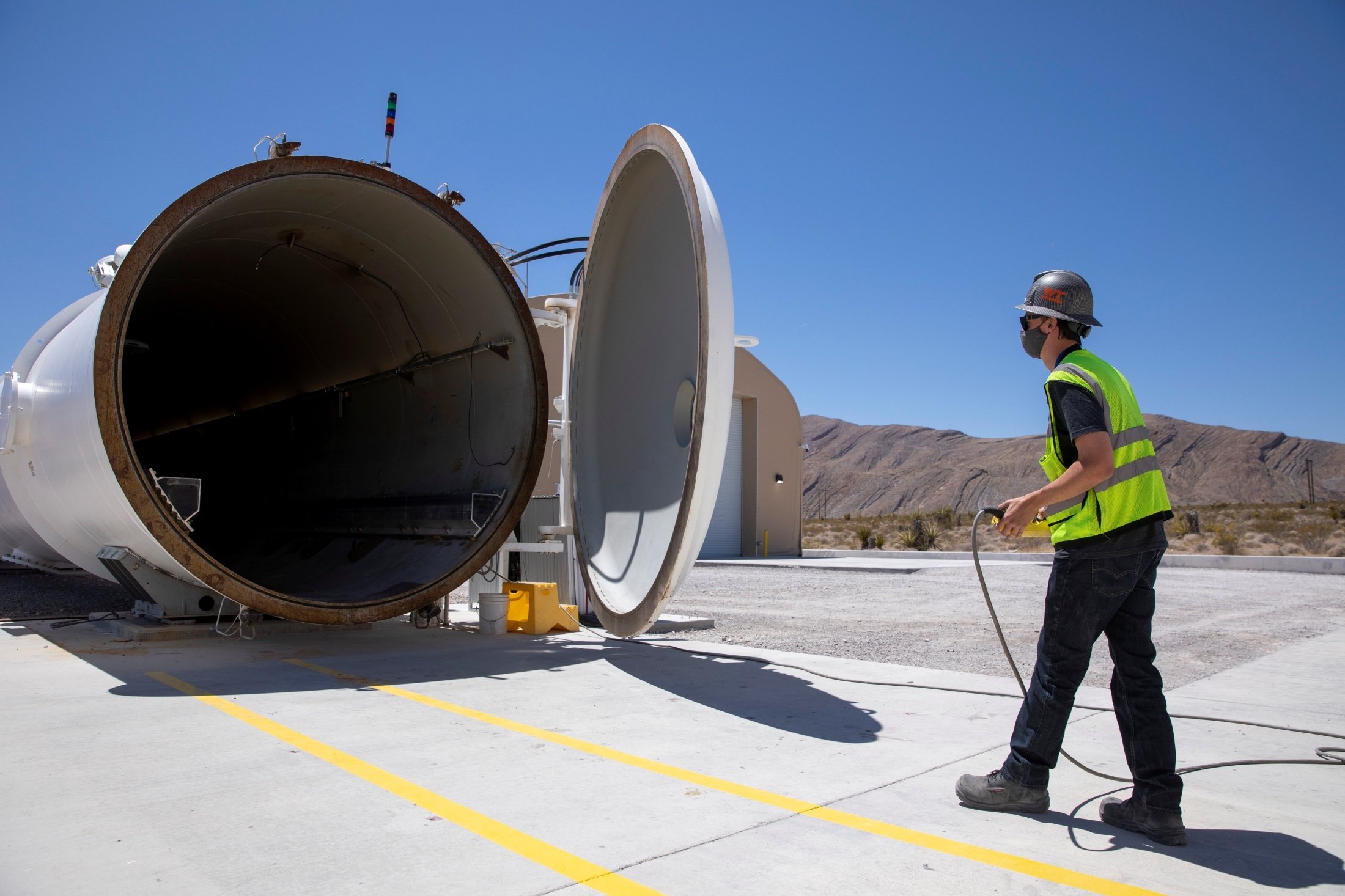 A worker closes the door on the test hyperloop tube at the Virgin Hyperloop facility near Las Vegas, Nevada, U.S., May 5, 2021. (Reuters Photo)