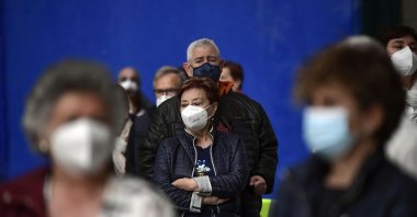 People wearing face masks wait to receive a shot of the Pfizer vaccine during a COVID-19 vaccination campaign, in Pamplona, northern Spain, May 7, 2021. (AP Photo)