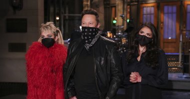 Musical guest Miley Cyrus (L), host Elon Musk (C), and Cecily Strong (R) appear on stage for the sketch comedy and variety show “Saturday Night Live,” during promos in Studio 8H in New York City, U.S., May 6, 2021. (NBC via AP)