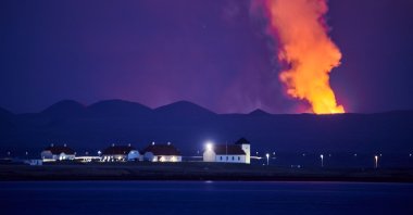 Bessastadir, the official residence of the president of Iceland, is pictured against the backdrop of the smoking Fagradalsfjall on the Reykjanes Peninsula, Reykjavik, Iceland, May 5, 2021. (AFP)