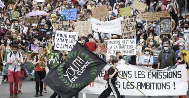 A demonstrator holds a flag reading "Youth for Climate" during a "march for climate" called by several NGOs and unions as part of a national day of action to demand climate justice in Nantes, western France, May 9, 2021. (AFP Photo)