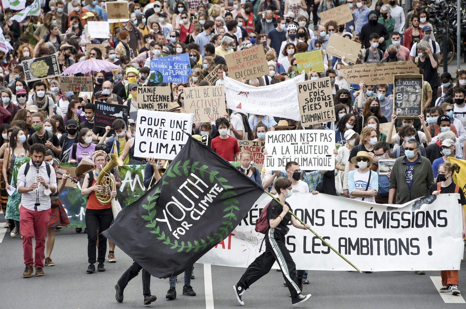 A demonstrator holds a flag reading "Youth for Climate" during a "march for climate" called by several NGOs and unions as part of a national day of action to demand climate justice in Nantes, western France, May 9, 2021. (AFP Photo)