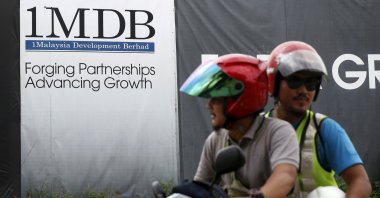Motorcyclists pass a 1Malaysia Development Berhad (1MDB) billboard at the Tun Razak Exchange development in Kuala Lumpur, Malaysia, Feb. 3, 2016. (Reuters Photo)