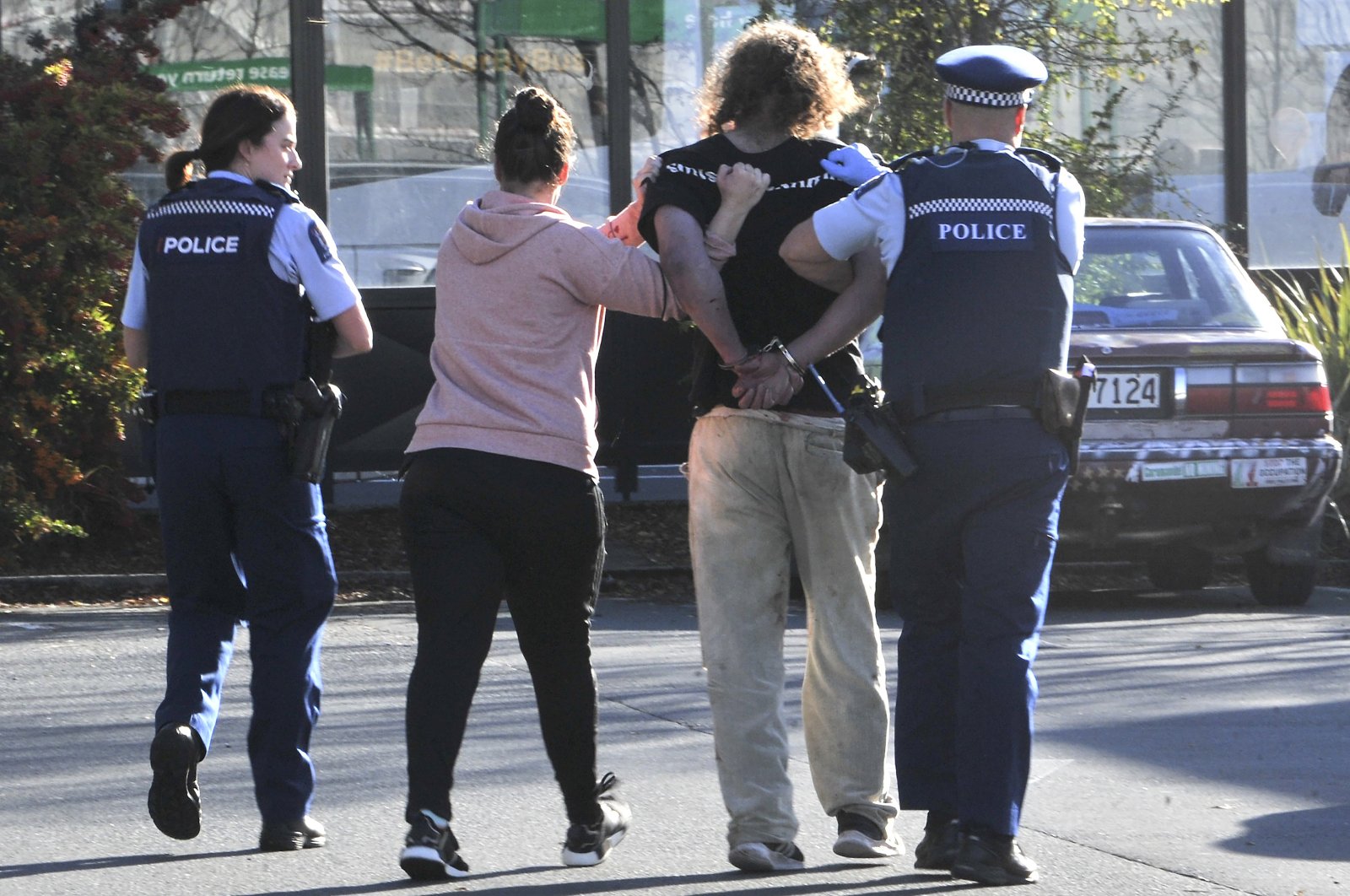 Police take a suspect into custody near the Countdown supermarket in central Dunedin, New Zealand, May 10, 2021. (AP Photo)