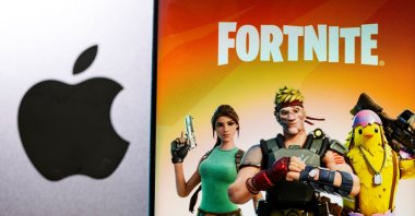The Fortnite game graphic is displayed on a smartphone in front of Apple logo in this illustration taken, May 2, 2021. (REUTERS Photo)
