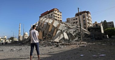 A Palestinian man looks at a destroyed building in Gaza City, following a series of Israeli airstrikes on the Gaza Strip, Palestine, May 12, 2021. (AFP Photo)