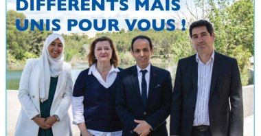 Sara Zemmahi (L) wearing a headscarf on a local election poster that reads "Different But United For You.”