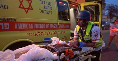 Rescue workers evacuate a an injured youngster by ambulance, amidst a rocket attack from the Gaza Strip, in the southern Israeli city of Sderot, on May 12, 2021. (AFP File Photo)