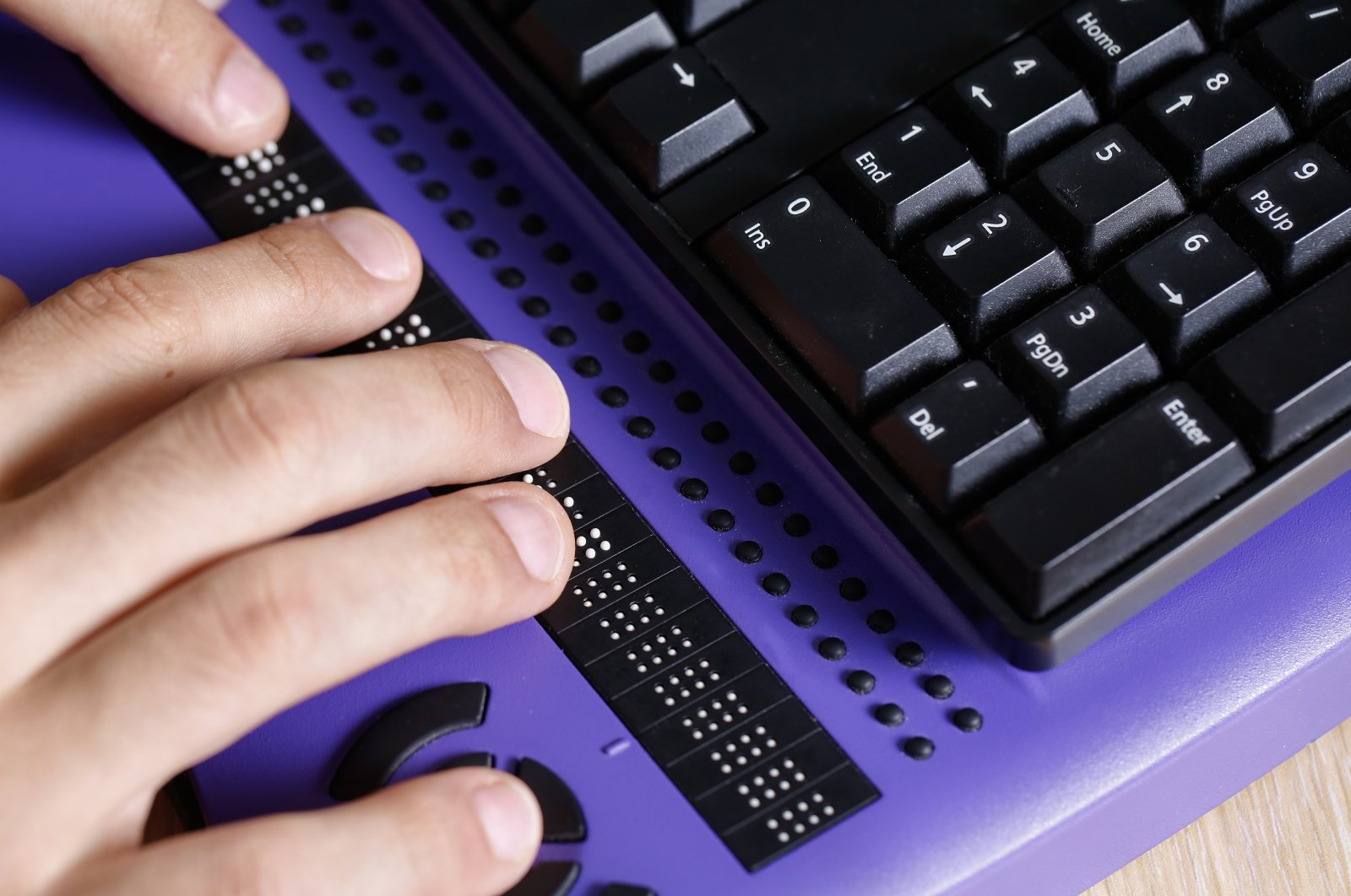 A visually impaired person using a computer with a braille keyboard is shown in this undated photo. (Shutterstock Photo)