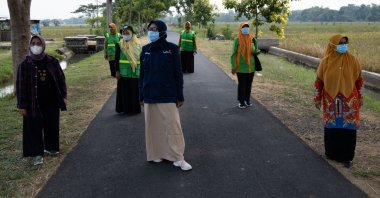National and regional leaders of 'Aisyiyah's environmental chapter stand between trees the group planted in Sukoharjo, Central Java province, Indonesia on May 5, 2021.(Reuters/Harry Jacques Photo)