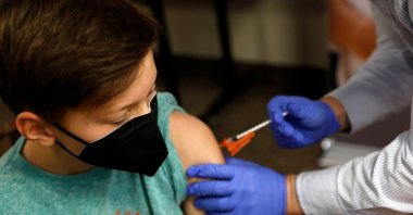Aiden Arthurs (L) is given a dose of the Pfizer-BioNTech COVID-19 vaccine by Andrew Mac at the Jewish Federation/JARC's offices in Bloomfield Hills, Michigan, May 13, 2021. (AFP Photo)