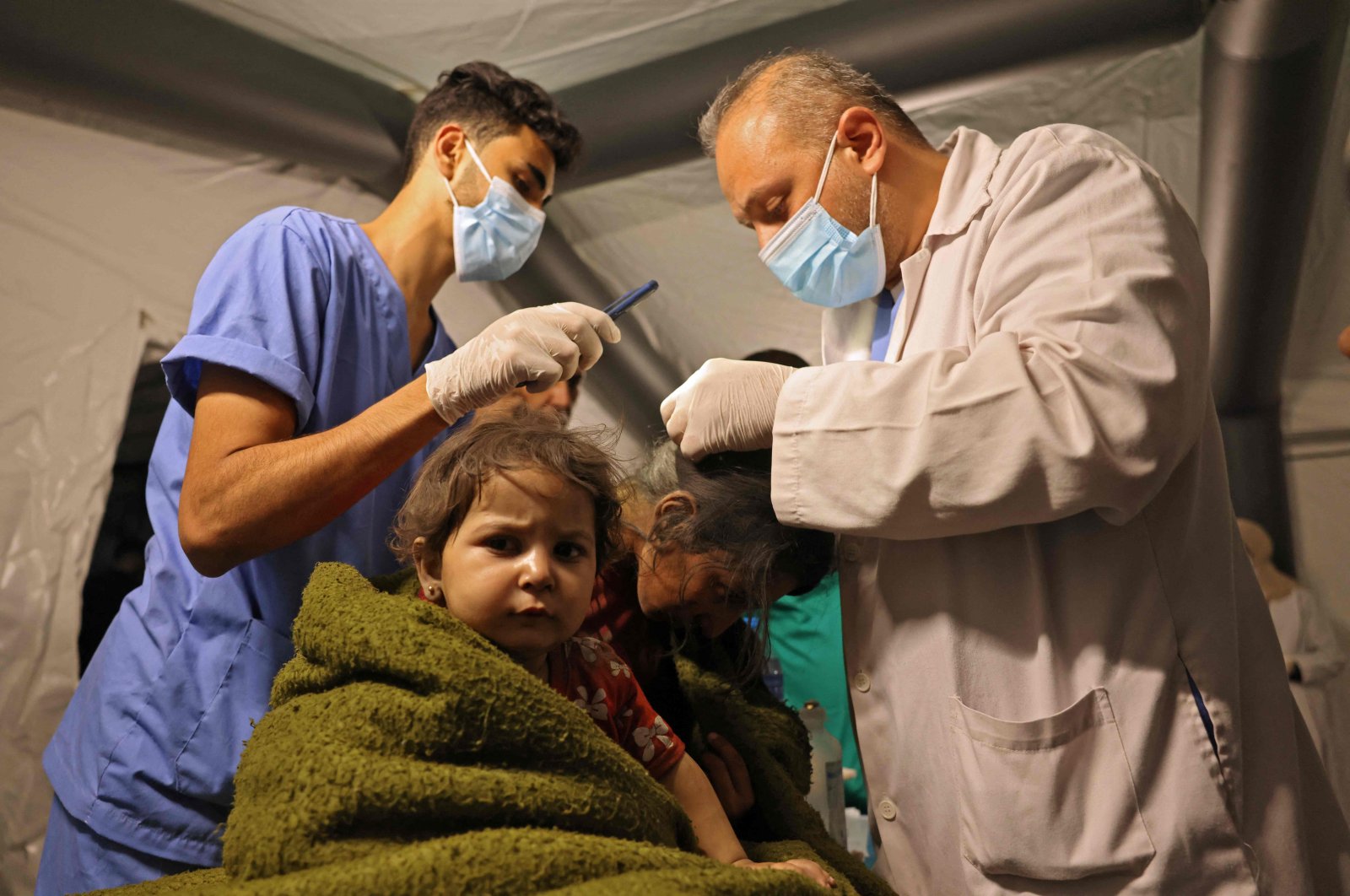 Medics tend to a Palestinian child injured in the aftermath of an Israeli airstrike at a make-shift hospital emergency ward in Rafah in the southern Gaza Strip on May 13, 2021. (AFP Photo)