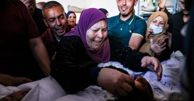 The grandmother and relatives of three children from the Al-Tanani family, killed in an Israeli airstrike, mourn over their bodies, before their burial in Beit Lahya in northern Gaza Strip, Palestine, May 14, 2021. (AFP Photo)