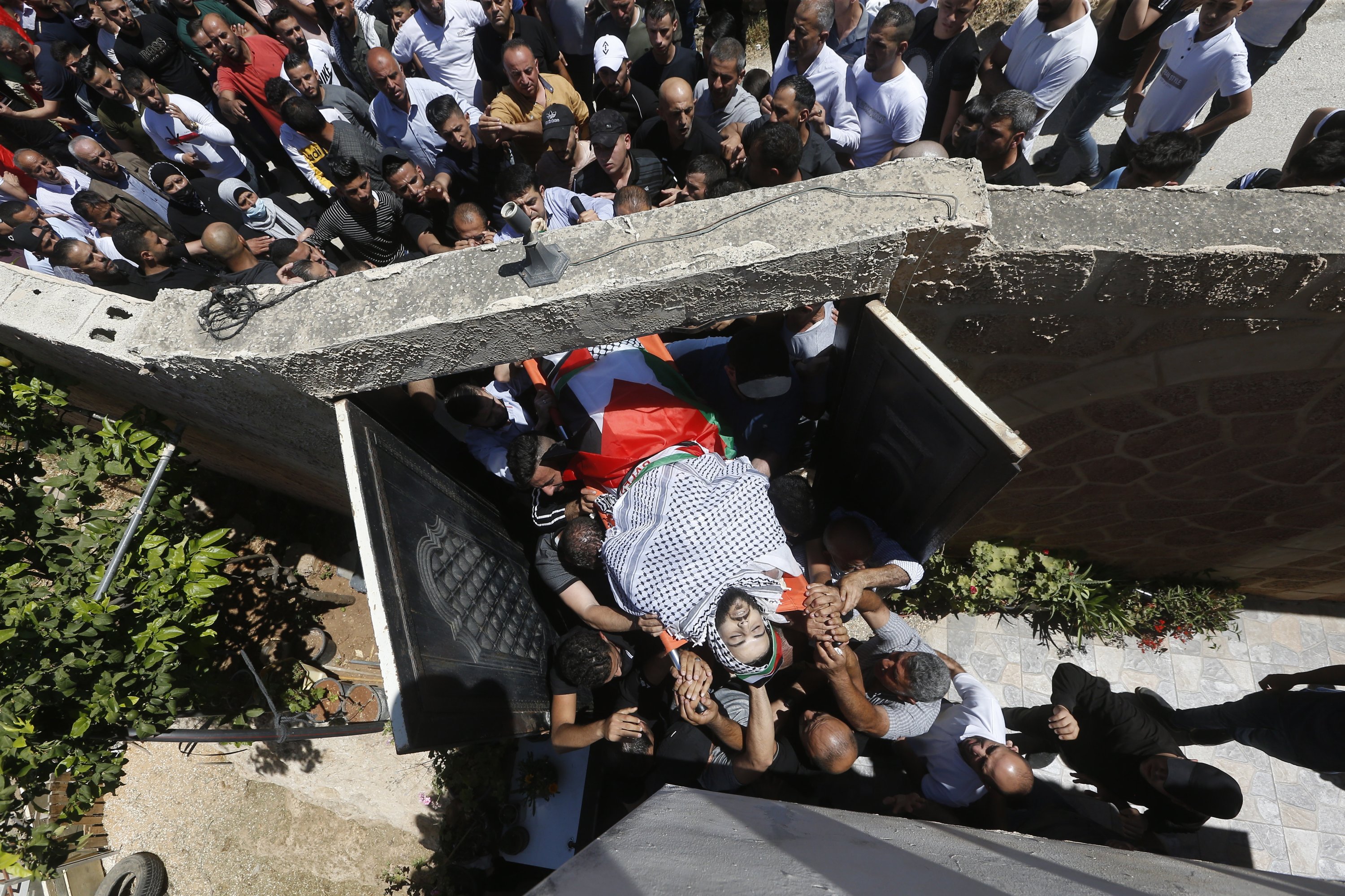 Mourners carry the body of Palestinian Malik Hamdan, who was killed by Israeli troops, during his funeral in the village of Salem near Nablus, in the occupied West Bank, Palestine, May 15, 2021. (EPA Photo)