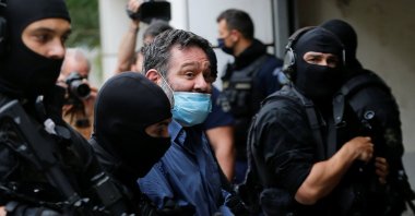 Ioannis Lagos (C), a Greek member of the European Parliament and former member of the far-right Golden Dawn party, is escorted by anti-terrorism police officers to the prosecutor's office in Athens, Greece, May 15, 2021. (REUTERS)