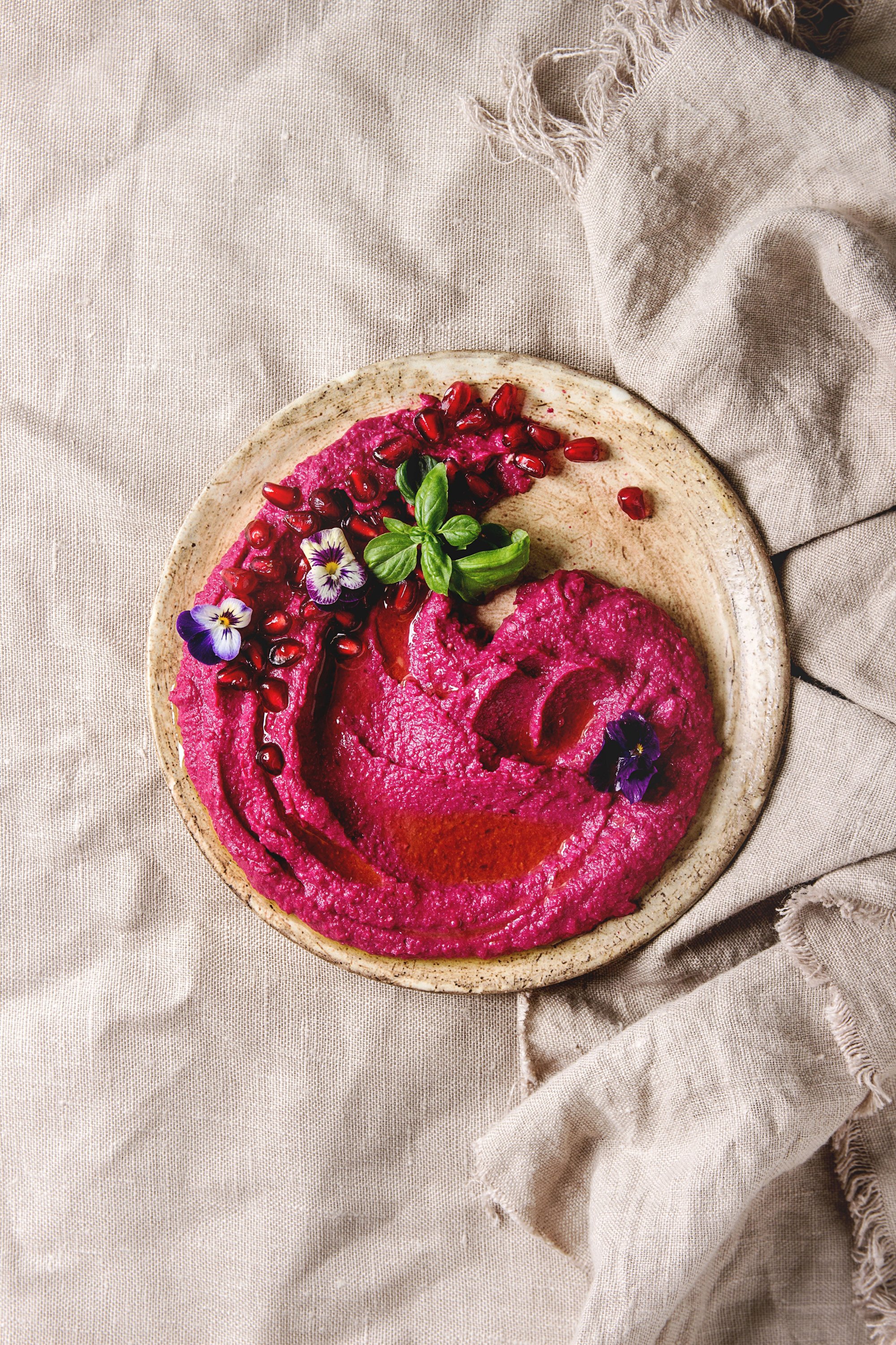 Homemade beetroot hummus can be topped off with pomegranate seeds, olive oil and basil. (Universal Images Group via Getty Images)