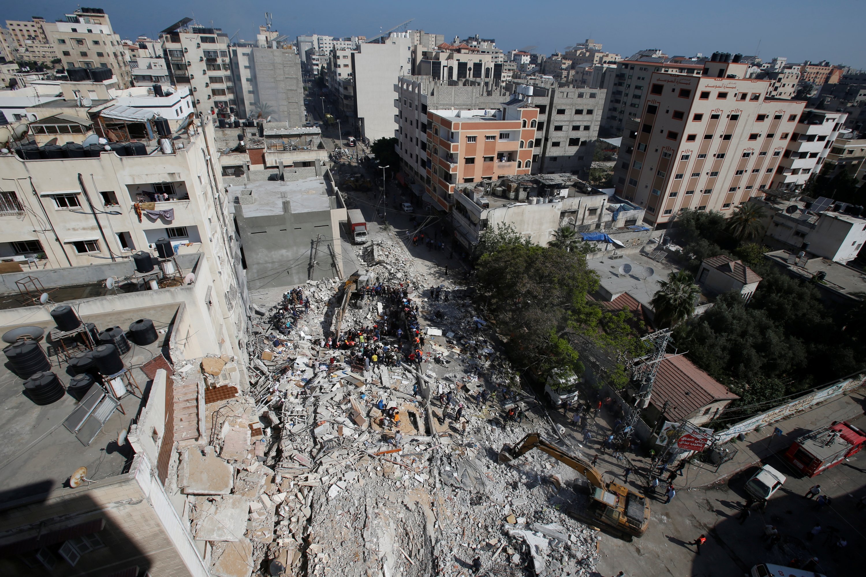 Rescuers search for people in the rubble of a building at the site of Israeli airstrikes, in Gaza City, May 16, 2021. (Reuters Photo)