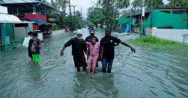 Police and rescue personnel evacuate a local resident through a flooded street in a coastal area after heavy rains under the influence of cyclone 'Tauktae' in Kochi, India, May 14, 2021. (AFP Photo)