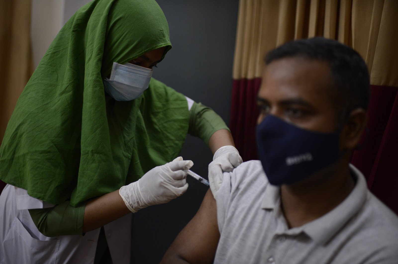 A Bangladeshi man receives a vaccine for COVID-19 at a hospital in Dhaka, Bangladesh, Saturday, May 8, 2021. (AP Photo)
