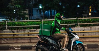 This undated handout photo received from GoTo Group shows a Gojek rider delivering a Tokopedia package to a customer in Jakarta, Indonesia, May 17, 2021. (AFP Photo)