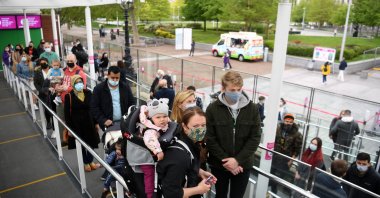 Customers wearing face coverings queue to board a pod on the re-opened London Eye tourist attraction in London as COVID-19 lockdown restrictions ease across the U.K., May 17, 2021. (AFP Photo)