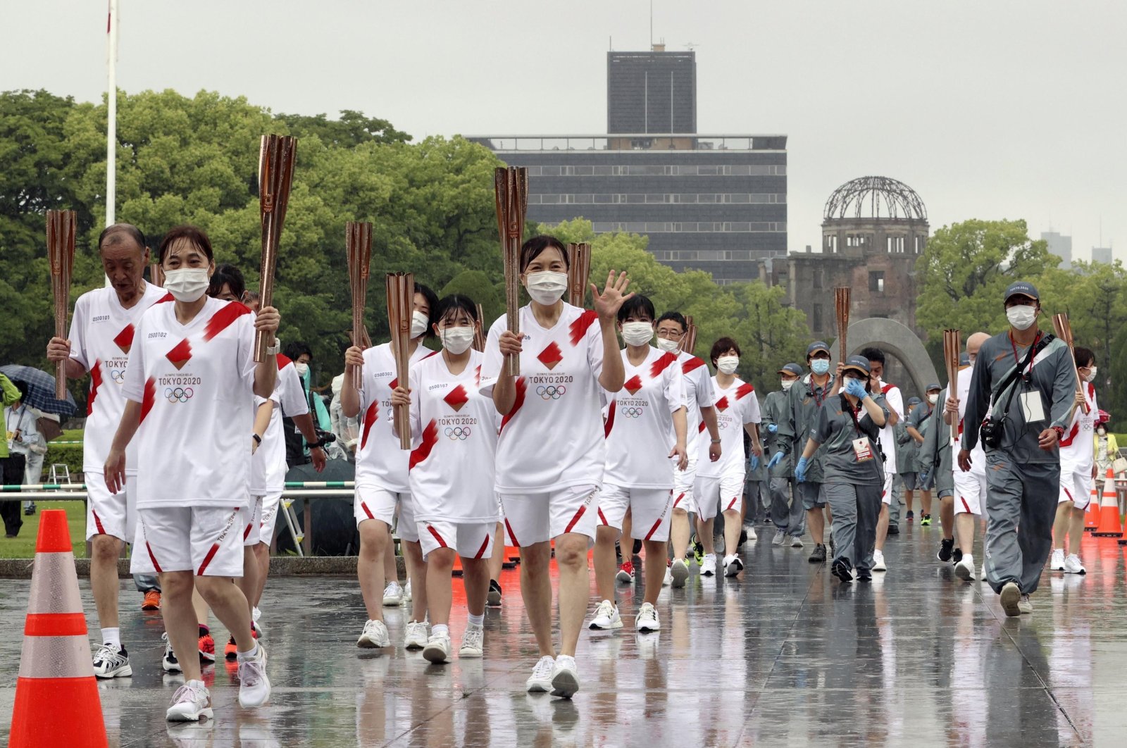 Tokyo 2020 Olympic torch relay participants pass the Atomic Bomb Dome in the background during the event without spectators due to the COVID-19 outbreak, at Peace Memorial Park in Hiroshima, Japan May 17, 2021. (Reuters Photo)