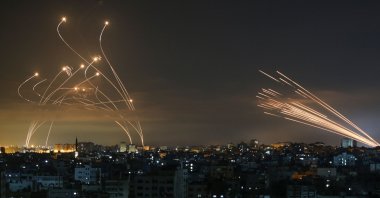 The Israeli Iron Dome missile defence system (L) intercepts rockets (R) fired by the Hamas towards southern Israel from Beit Lahia in the northern Gaza Strip as seen in the sky above the Gaza Strip overnight on May 14, 2021. (AFP Photo)