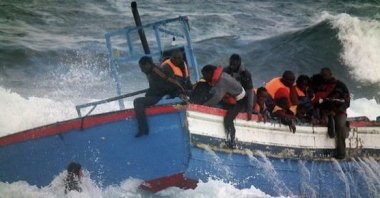 Italian Coast Guard scuba divers, seen bottom left, rescue migrants in Pantelleria, Italy, April 13, 2011. (Italian Coast Guard via AP)