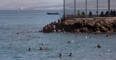 Migrants swim to cross the border of Tarajal in Ceuta, Spain. On the night of 18 May, a total of 5,000 Moroccan nationals entered the Spanish city of Ceuta, located on the North African coast, May 18, 2021. (EPA / BRAIS LORENZO)
