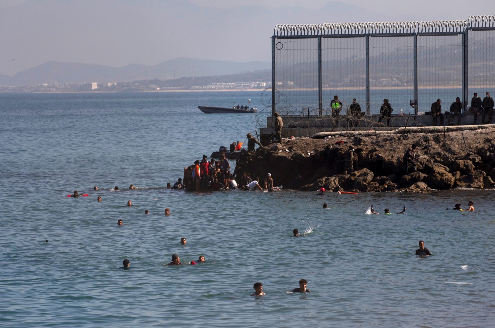 Migrants swim to cross the border of Tarajal in Ceuta, Spain. On the night of 18 May, a total of 5,000 Moroccan nationals entered the Spanish city of Ceuta, located on the North African coast, May 18, 2021. (EPA / BRAIS LORENZO)