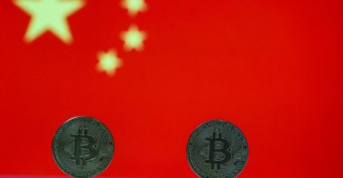 Tangible Bitcoin coins are seen in front of a Chinese flag in this illustration photo, May 18, 2021. (AA Photo)