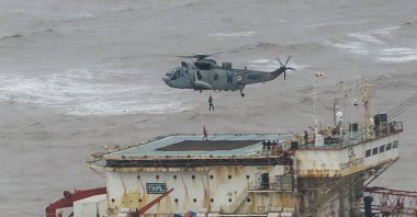 Stranded workers are airlifted by naval personnel on an Indian Navy Seaking helicopter from a barge that had gone adrift amidst heavy rain and strong winds due to Cyclone Tauktae, the Arabian Sea, May 18, 2021. (Indian Navy handout photo via AFP)