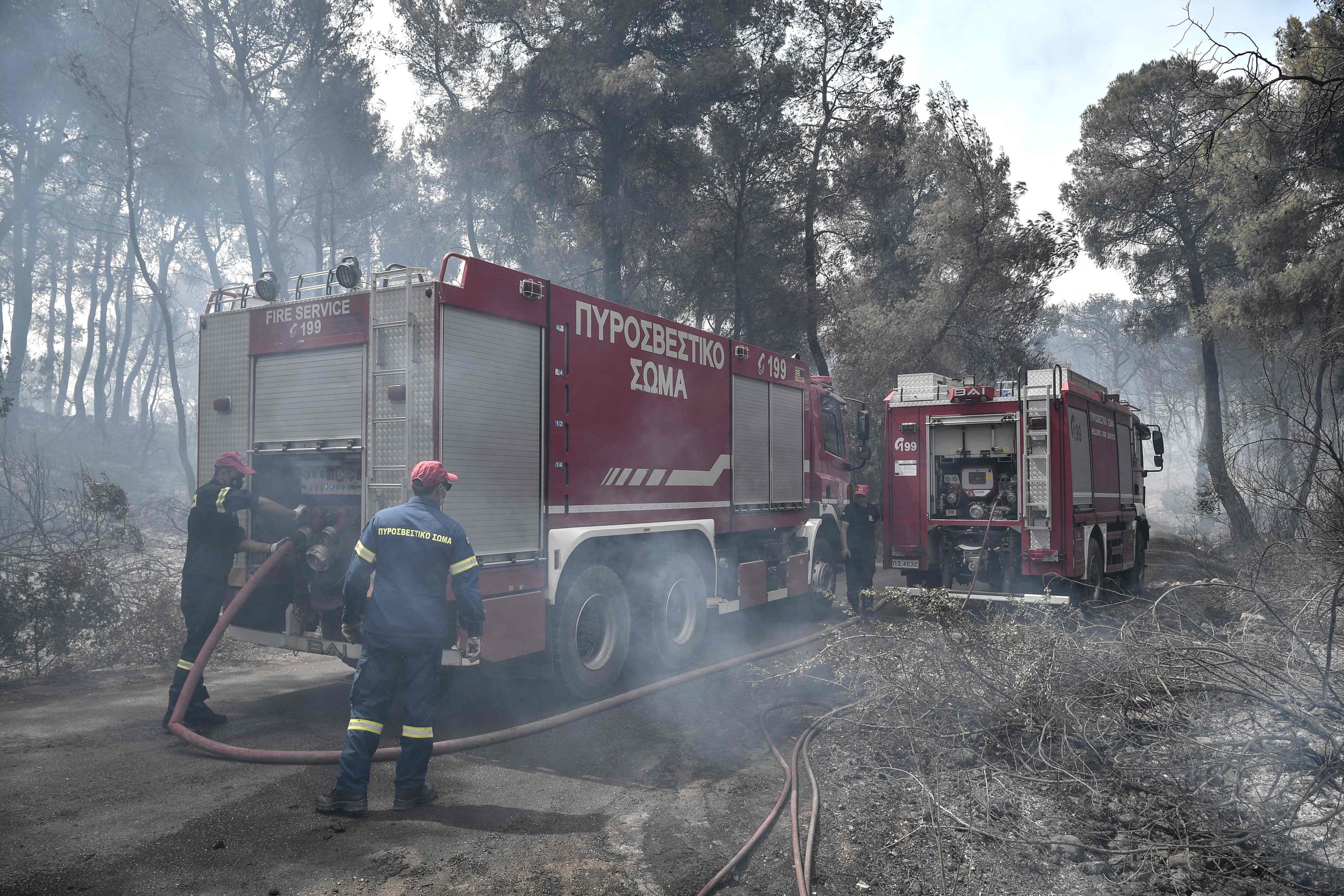 After there was an overnight fire on a mountain range overlooking the Gulf of Corinth, firemen battle a forest near the village of Mazi, Greece, May 20, 2021. (AFP Photo)