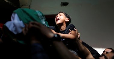 A Palestinian boy cries for his brother Ahmed Al-Shenbari, who was killed by Israeli bombardments, as mourners carry his body during his funeral in the northern Gaza Strip, Palestine, May 11, 2021. (Reuters Photo)