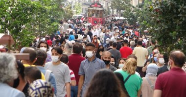 People with face masks walk on Istiklal Street near Istanbul’s famous Taksim square after a 17-day total lockdown across Turkey, May 17, 2021. (IHA Photo)