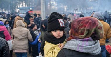 A child looks on as migrants wait to pass the buffer zone at the Turkey-Greece border, Pazarkule, Edirne province, Turkey, Feb. 29, 2020. (AFP Photo)