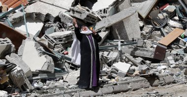 A woman reacts while standing near the rubble of a building that was destroyed by an Israeli airstrike in the Gaza Strip, Palestine, May 16, 2021. (AP Photo)