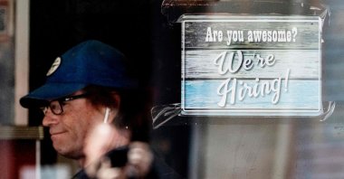 A man eats breakfast at a restaurant that has a job advertisement displayed at its window in Annapolis, Maryland, U.S., May 12, 2021. (AFP Photo)