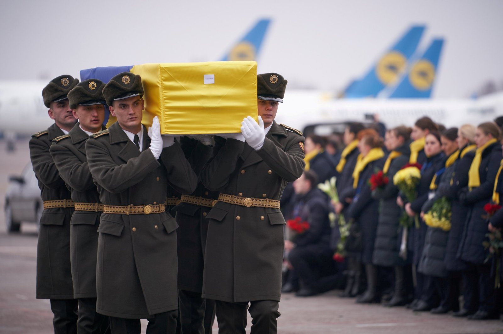 Soldiers carry a coffin containing the remains of one of the 11 Ukrainian victims of the Ukraine International Airlines flight 752 plane disaster during a memorial ceremony at the Boryspil International Airport, outside Kyiv, Ukraine, Jan. 19, 2020. (Ukrainian Presidential Press Service via Reuters)