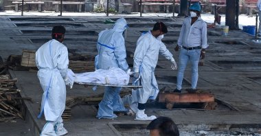 Ambulance staff carry the dead body of a patient who died from COVID-19 for cremation at a crematorium in New Delhi, India, May 21, 2021. (AFP Photo)