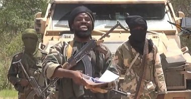 Boko Haram leader Abubakar Shekau (C) smiles in a video made and released by the terrorist group at an undisclosed location and date, in this screengrab taken on July 13, 2014. (AFP/Boko Haram/Getty Images)