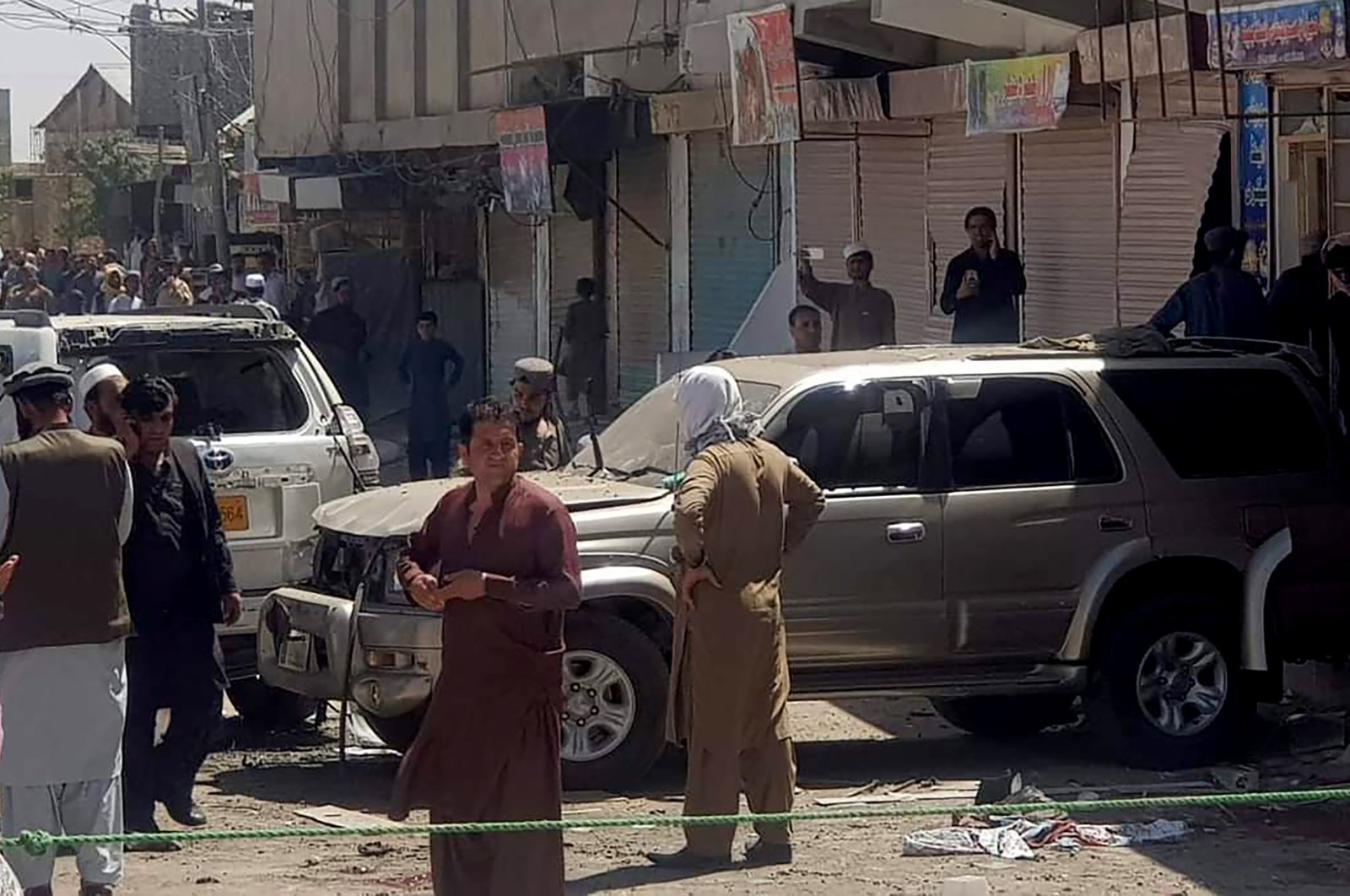 Police officers and local residents gather beside damaged vehicles at the site of a bomb blast in Chaman, southwestern Pakistan, May 21, 2021. (AP Photo)