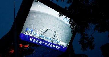 A screen broadcasts a CCTV state media news bulletin, showing an image of Mars taken by Chinese Mars rover Zhurong as part of the Tianwen-1 mission, in Beijing, China, May 19, 2021. (Reuters Photo)