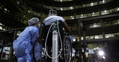 A nurse and her patient watch a performance by the Brasilia Philharmonic Orchestra, from the inner court of the HRAN Reference Hospital for COVID-19 in Brasilia, Brazil, Thursday, May 20, 2021. (AP Photo)